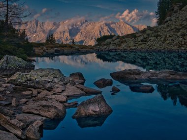 Sonbahar döneminde dağ gölü, kayalar, uçurumlar, ağaçlar ve su yüzeyiyle manzaralı dağ manzarası. Mystique doğayı rahatlatıyor. Spiegelsee-Reiteralm-Schladming-Dachstein tatil köyü, Avusturya. 