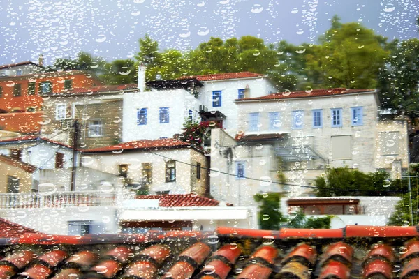 Yunanistan 'ın Hydra adasında, yağmurlu bir günde geleneksel evlerin bulanık görüntüsü.