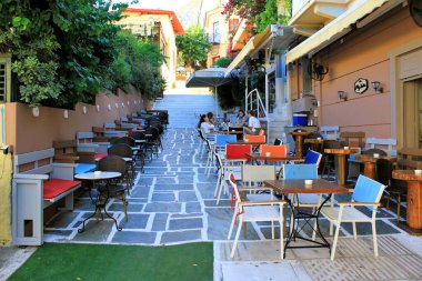 Yunanistan, Atina, 16 Haziran 2020 - Plaka bölgesinin en turistik noktalarından birinin manzarası neredeyse boş bir kafe restoranı. Coronavirüs (COVID-19) turizmi, tüm büyük ekonomik sektörlerin en kötü etkilerini meydana getirmiştir.).