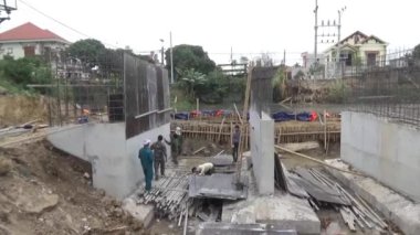 İşçiler nehir boyunca köprüler inşa ediyorlar.