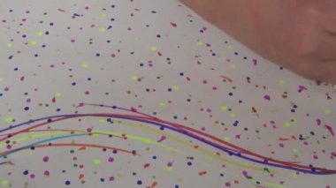 Küçük çocuk birçok pastel boya cümlesiyle çizim yapıyor.