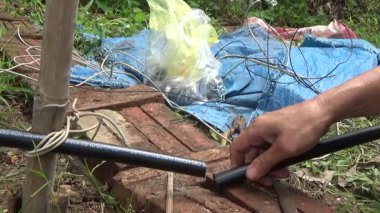 Çiftçi sebze bahçesi için su boruları kuruyor