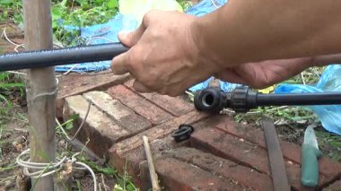 Çiftçi sebze bahçesi için su boruları kuruyor