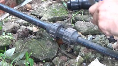 Çiftçi sebze bahçesi için su boruları kuruyor