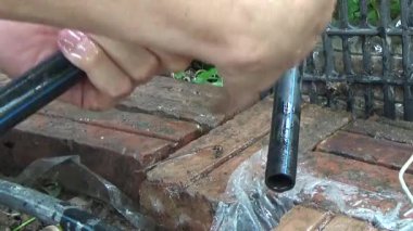 Çiftçi sebze bahçesi için su boruları kuruyor