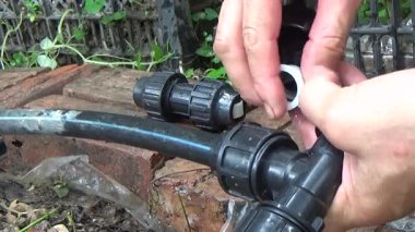 Çiftçi sebze bahçesi için su boruları kuruyor