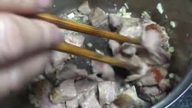 Domuzu parçalara ayır, eti baharatlarla terbiye et ve eti bir tencere yağda kızart.