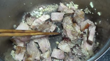 Domuzu parçalara ayır, eti baharatlarla terbiye et ve eti bir tencere yağda kızart.