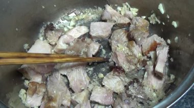 Domuzu parçalara ayır, eti baharatlarla terbiye et ve eti bir tencere yağda kızart.