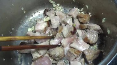 Domuzu parçalara ayır, eti baharatlarla terbiye et ve eti bir tencere yağda kızart.