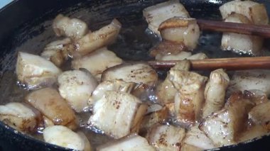 Domuzu parçalara ayır, eti baharatlarla terbiye et ve eti bir tencere yağda kızart.