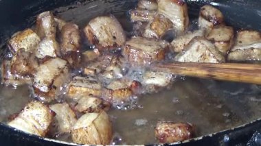 Domuzu parçalara ayır, eti baharatlarla terbiye et ve eti bir tencere yağda kızart.