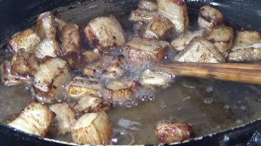 Domuzu parçalara ayır, eti baharatlarla terbiye et ve eti bir tencere yağda kızart.