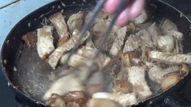 Domuzu parçalara ayır, eti baharatlarla terbiye et ve eti bir tencere yağda kızart.