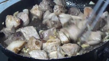 Domuzu parçalara ayır, eti baharatlarla terbiye et ve eti bir tencere yağda kızart.