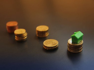 Euro sentlik demir bir koyu renkli arka plan üzerine dizilir. Bir yığının üstüne bir yazlık rakam duruyor. Kavram iş, Emlak, strateji, kazanmak