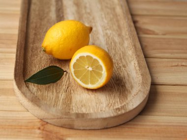 Limon tam ve yarım bir ahşap tepsi üzerinde yalan yakın çekim