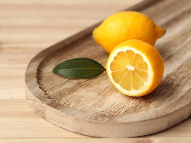 Limon tam ve yarım bir ahşap tepsi üzerinde yalan yakın çekim