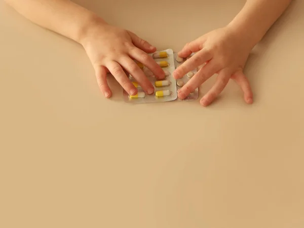 Las manos de los niños con pastillas sobre un fondo claro de cerca. Concepto salud — Foto de Stock