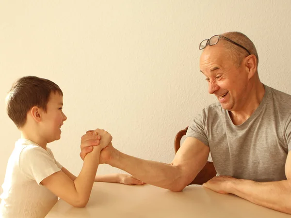 A boy and a man compete in armwrestling — Stock Photo, Image