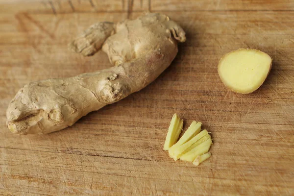 La fruta de jengibre es fresca, picada finamente, se encuentra en una base de madera ligera, el concepto de salud y alimentos — Foto de Stock