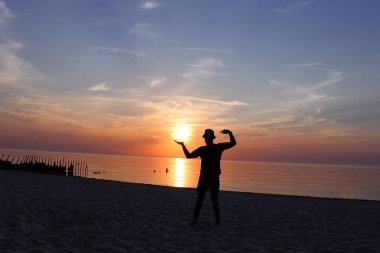 mavi deniz ve günbatımı gökyüzüne karşı bir adamın siyah siluet