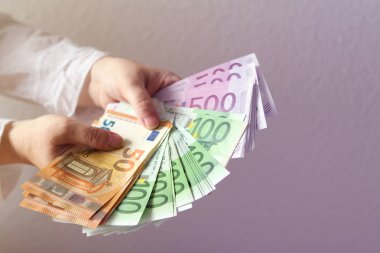 Kadın eller Euro banknotların, yakın çekim ışık arka planda tutun