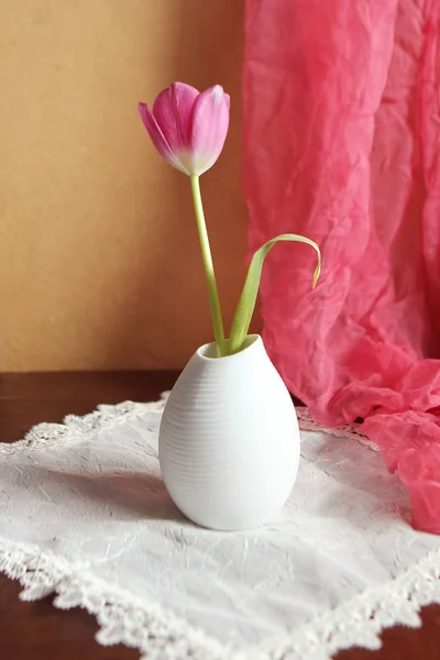 Stilleben med rosa tulpaner i en vit vas och drapera av en sidenscarf — Stockfoto