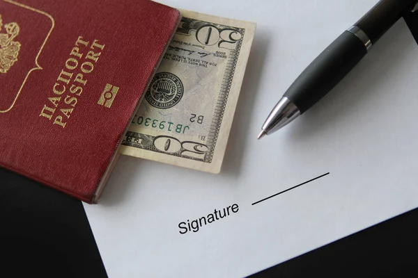 Passport with US dollars banknotes and pen. Signing a document. Topics of rent a car, car sharing, insurance compensation. Selective focus — Stock Photo, Image