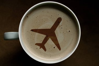Tahta arka planda cappuccino kahve fincan üst görünümü, uçakta sanat. Tatil konsepti, uçak uçuşu.