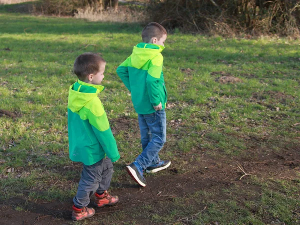 Jongens, twee, broers in groene windbreakers, gaan, uitzicht vanaf de achterkant — Stockfoto