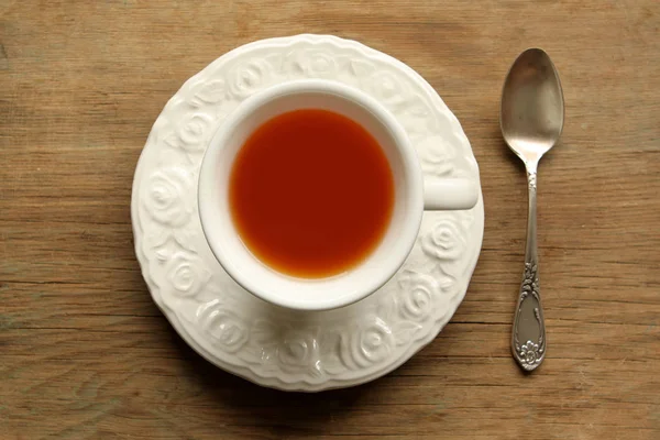 접시와 숟가락 나무 테이블에 흰색 컵에 차 — 스톡 사진