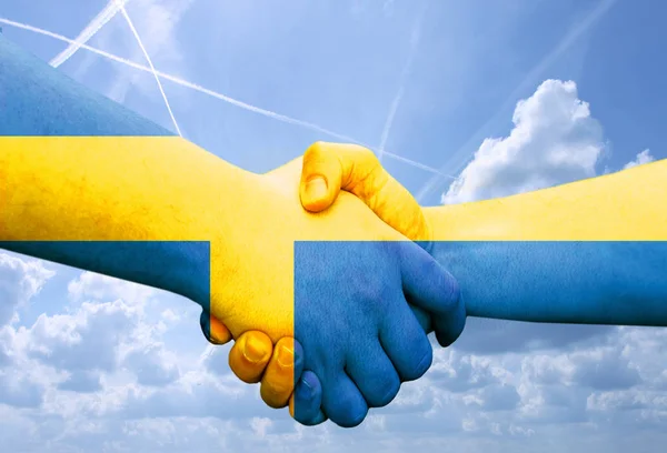 Mavi bir gökyüzü arka plan üzerinde, iki erkek elleri el sıkışırken dostluk ve tebrik gösteren renkli elleri ile bayrak İsveç tarafından yapılan jest — Stok fotoğraf
