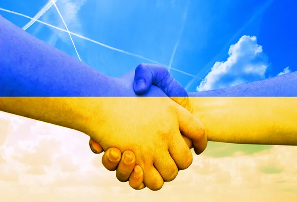 Gest wykonany przez flagę Ukrainy z kolorowymi rękami pokazując przyjaźń i pozdrowienia z dwoma męskimi rękami drżenie rąk, na niebieskim tle nieba — Zdjęcie stockowe