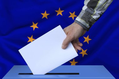 erkek el Avrupa Birliği bayrağının arka planına karşı oy pusulasıkoyar, Avrupa Parlamentosu'na seçim kavramı