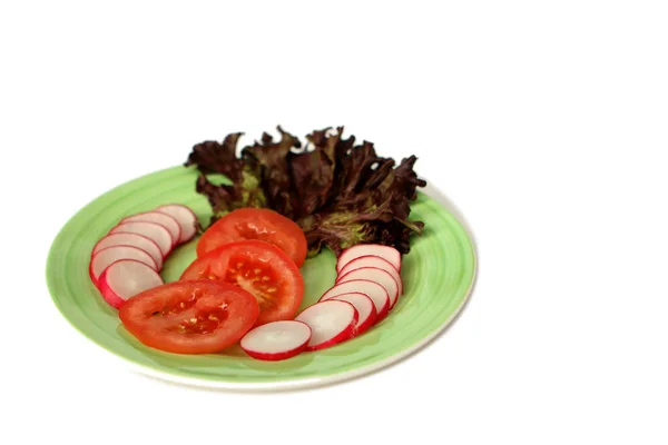 Свежие овощи: помидоры, редис и салат на светло-зеленой тарелке, изолировать, копировать пространство — стоковое фото