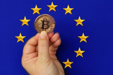 Avrupa Birliği bayrağının arka planda kadın elinde bitcoin kripto para birimi