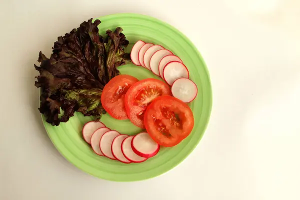新鲜蔬菜：西红柿、萝卜和生菜放在浅绿色的盘子上，顶视图，复制空间 — 图库照片