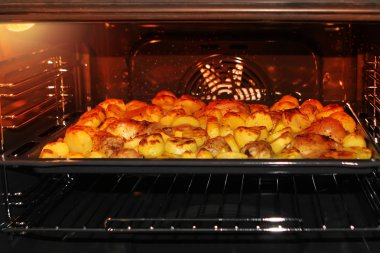 Tavada tavuk ve curcuma ve diğer baharatlar ile Fırında patates. Arka planda fırın