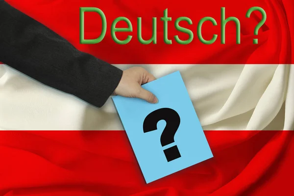 Hand of the teacher holds a sheet with a question mark on the background of the inscription in German "German?" and beautiful flag of Austria on pleated fabric — Stock Photo, Image