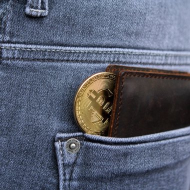 Cryptocurrency sikke altın Bitcoin erkek gri kot arka cebinde bir deri cüzdan yatıyor, kare, yakın çekim