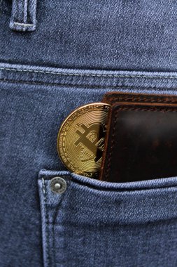 Cryptocurrency sikke altın Bitcoin erkek gri kot arka cebinde bir deri cüzdan yatıyor, yakın çekim, dikey