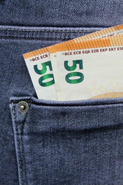 Money euro notes, 50 euros each peeking out of the pocket of jeans, the concept of theft, vertical — Stockfoto