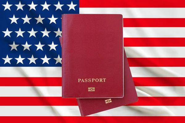 Two passports lying on each other against the background of the USA flag, copy space in the center, naturalization and immigration concept — Stock Photo, Image