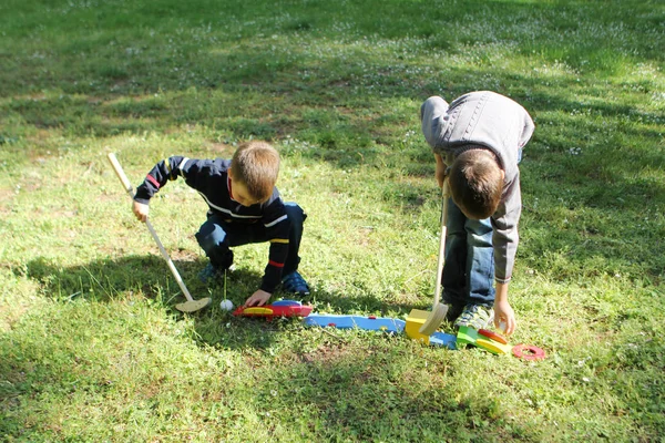 Dois escola e pré-escolar meninos jogar madeira mini golfe na grama fora, conceito de jogos de verão no ar fresco — Fotografia de Stock