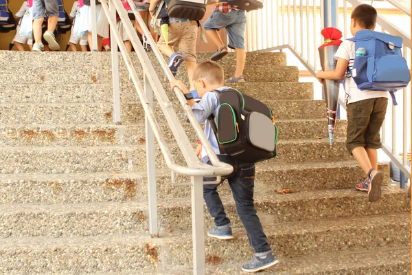 Школьники поднимаются по лестнице в здание школы, концепция возвращается в школу — стоковое фото