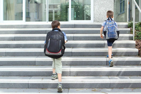 pupils with school backpacks climb the school stairs, Back to school concept