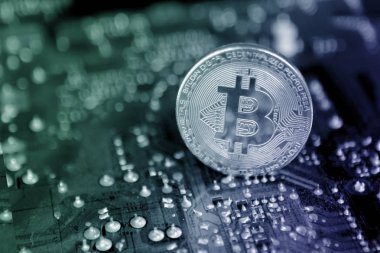 Elektronik sikke, anakart karanlık bir arka planda gümüş sikke, konsept madenciliği, kopya alanı, yakın çekim, yatay