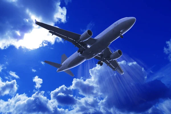 Avión de pasajeros volando en el cielo azul con nubes — Foto de Stock