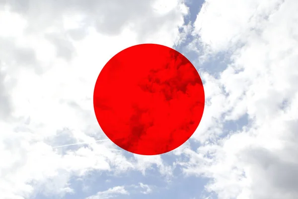 beautiful national flag of japan on soft silk with soft folds, close-up, copy space on blue sky background